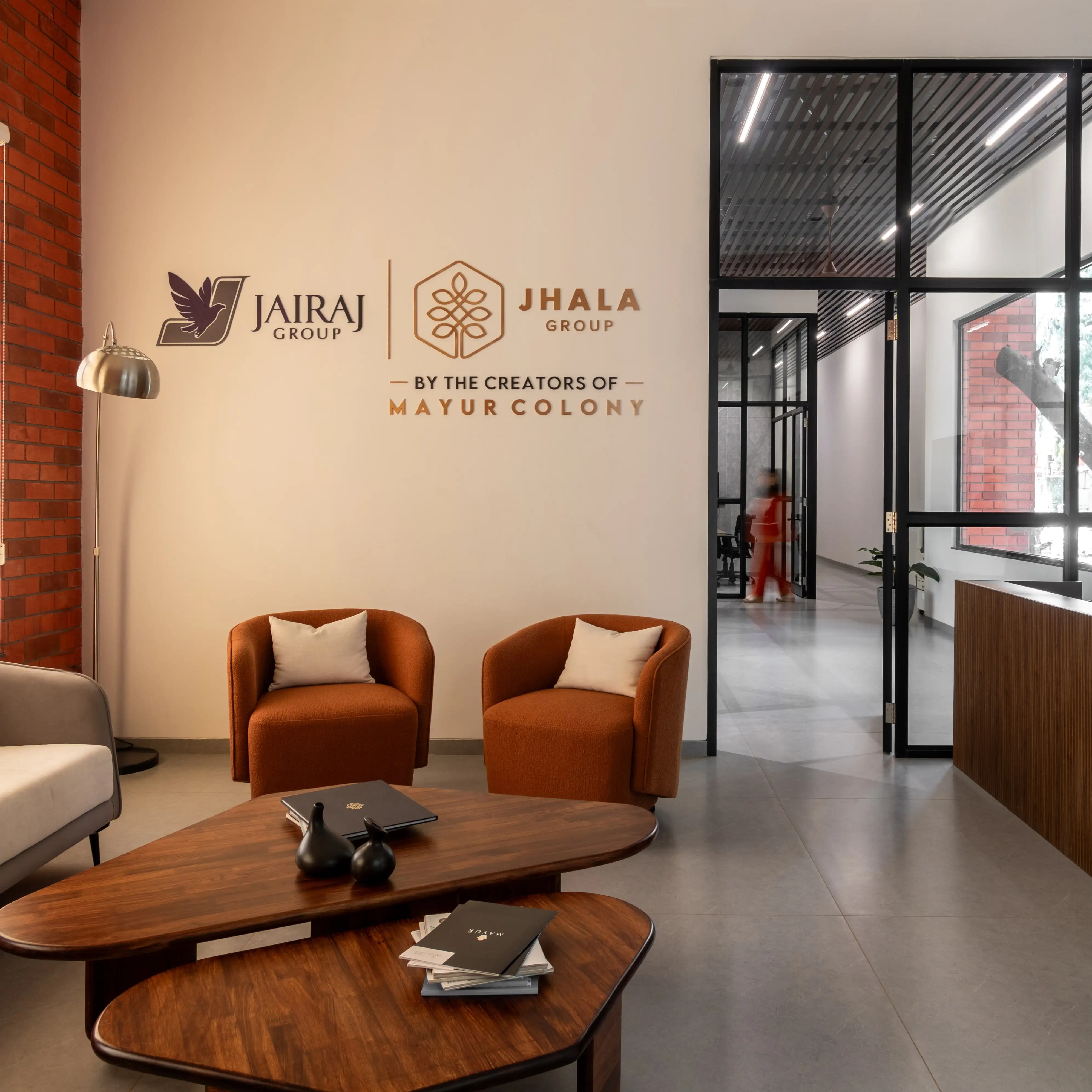 Reception area with warm timber furniture, brick walls and orange armchairs